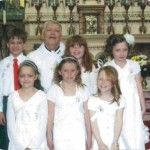 Permalink to First Holy Communion Joy in Whitby photo of Father Neil McNicholas with First Holy Communion children at Whitby