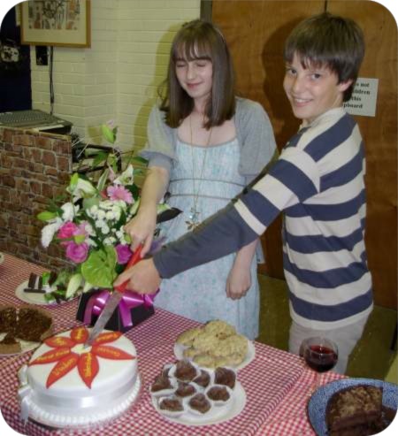 photo of youngsters cutting celebration cake