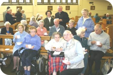 photo of Bishop Terry having a cup of tea with some of those he had anointed