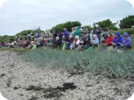 photo of hardy pilgrims praying on the beach