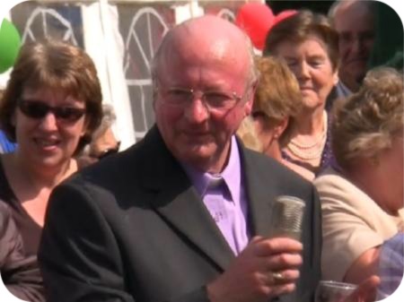 photo of Father Pat Smith raising a glass