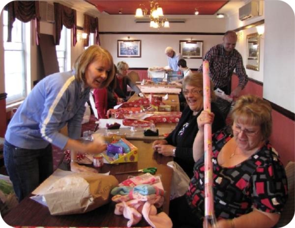 photo of Jane Morgan (left) and volunteers wrapping presents