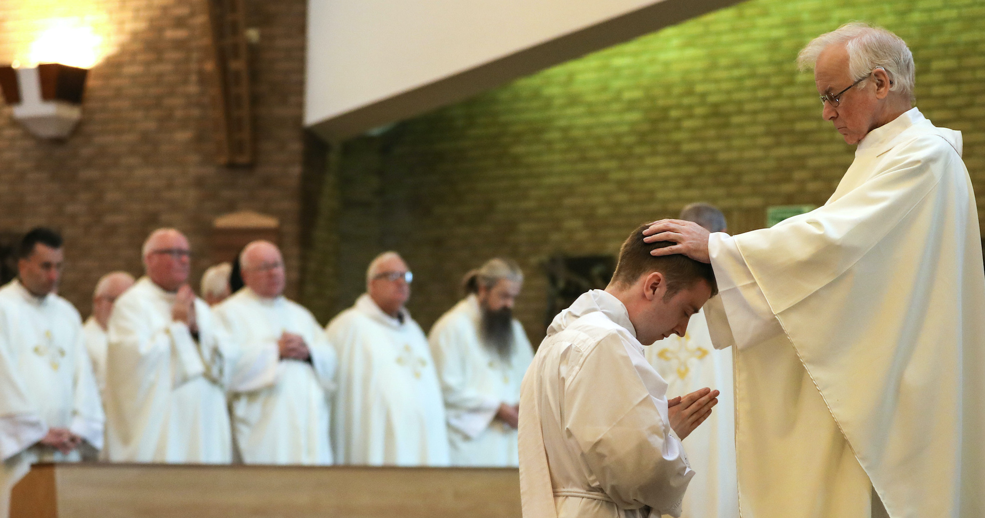 Father John Wood laying hands on the newly ordained Father Peter Taylor at St Mary's Cathedral in September 2019 – Photo by Chris Booth