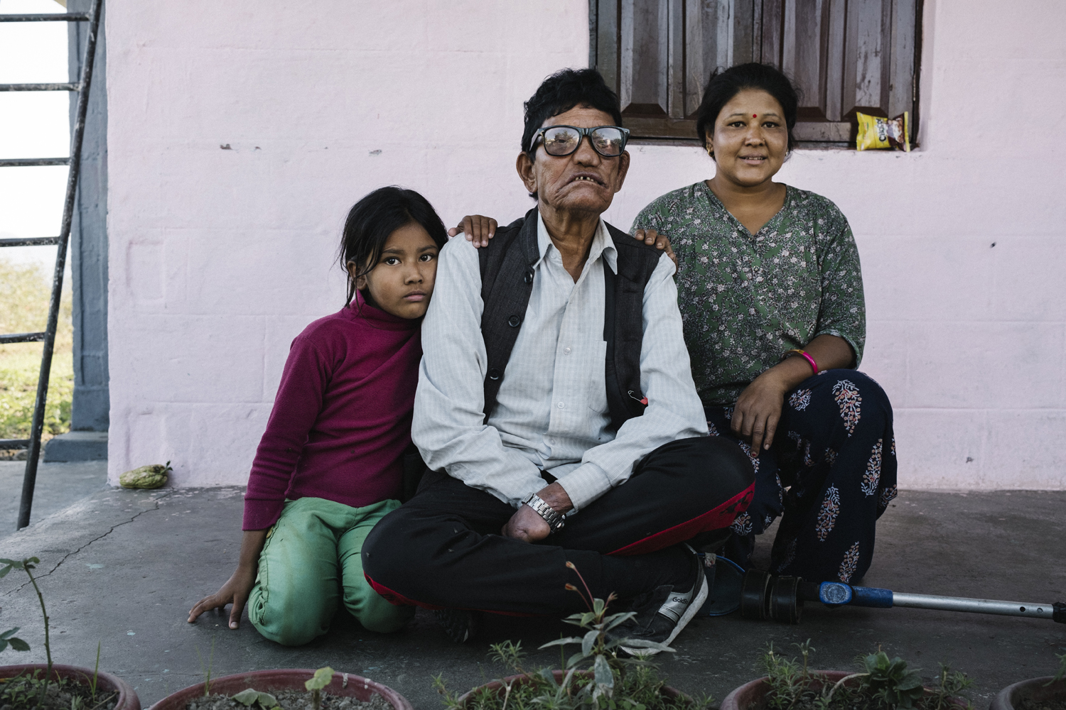 Dal Bahadur Pariyar (centre) who lives at the Lamatara Leprosy Settlement, south of Pokhara in Nepal. Dal is pictured with his daughter and granddaughter—Photograph by kind permission of Tom Bradley