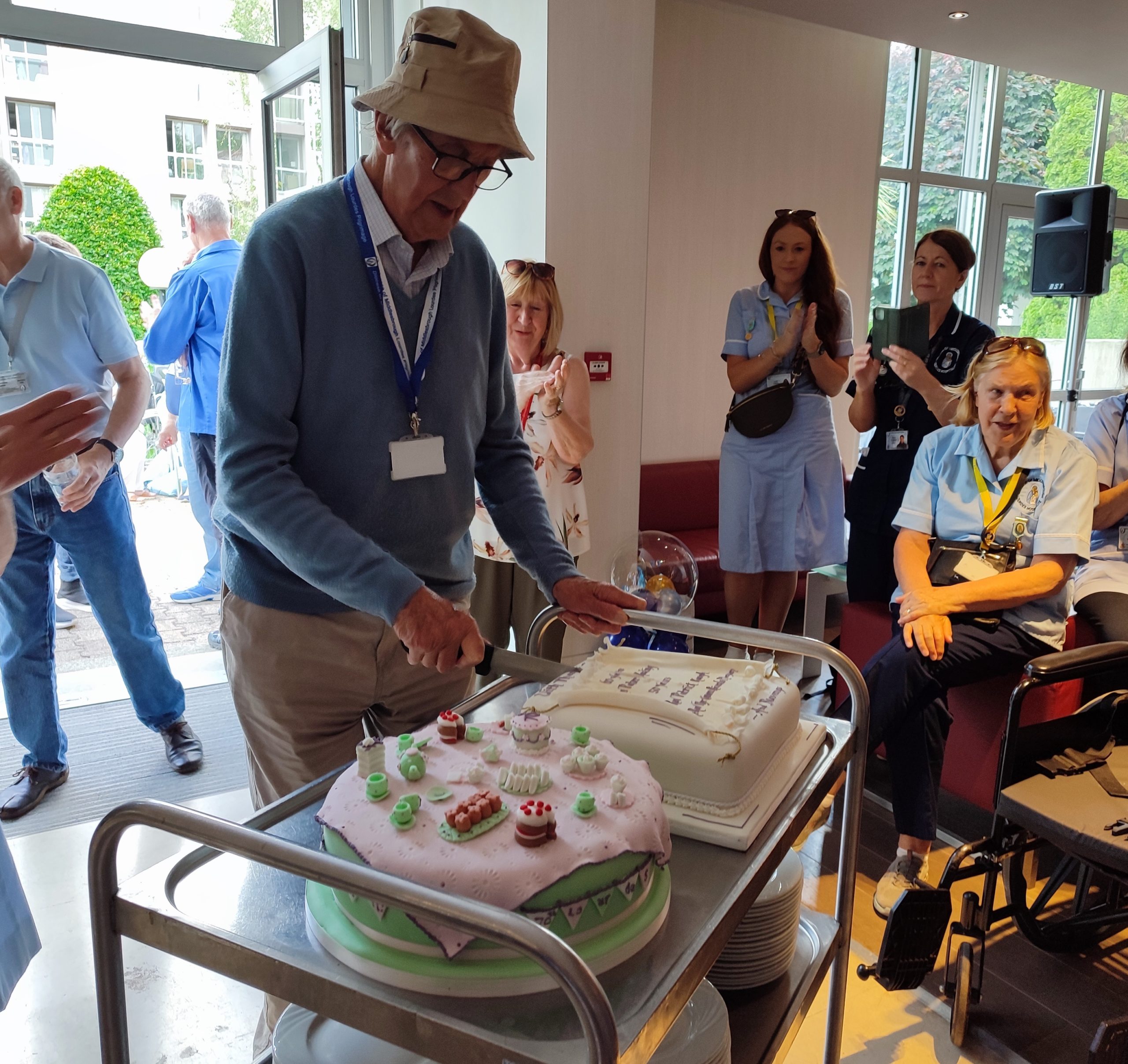 Father Peter Keeling cutting a cake in Lourdes to celebrate the 60th anniversary of his ordination in 2023 – Photo by Michael McGeary