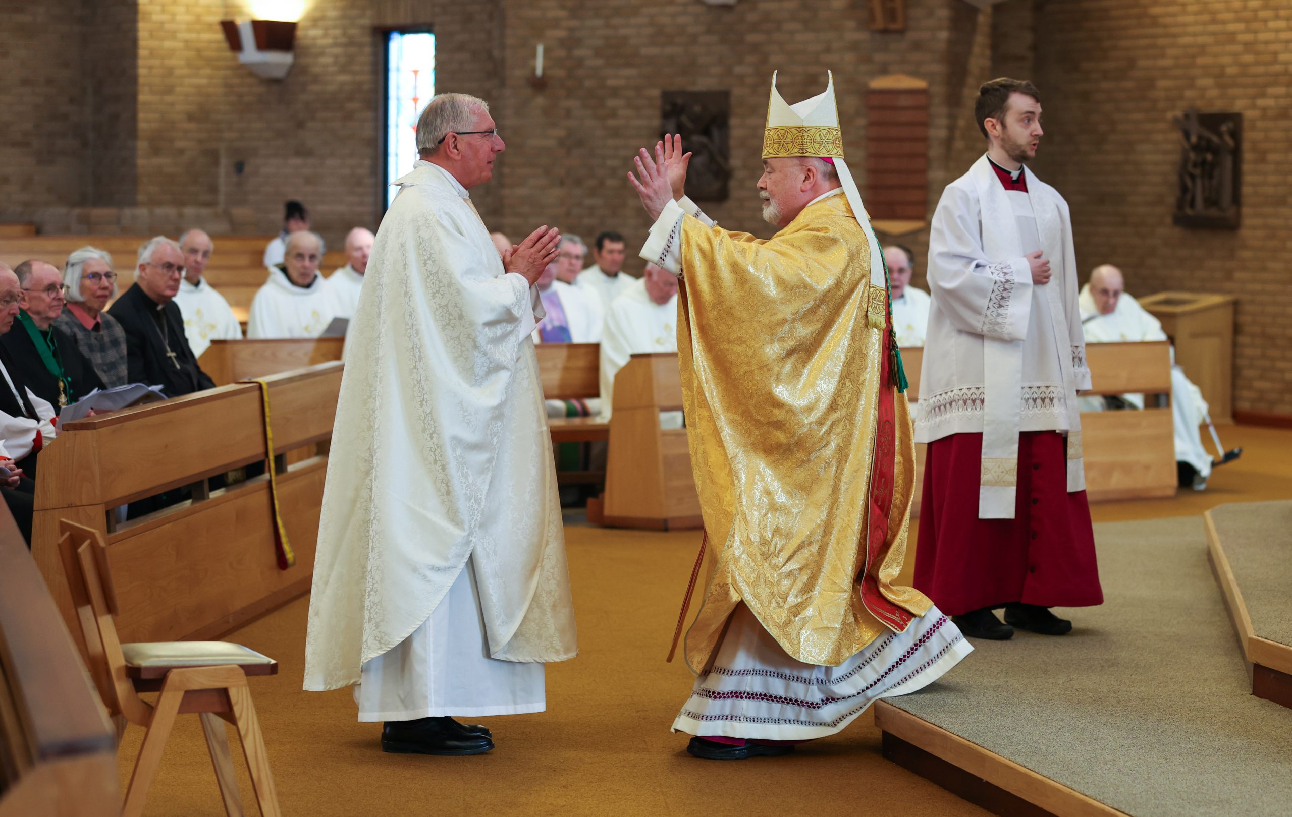 Bishop Marcus Stock greets the newly ordained Father Douglas McKittrick – Photo by Chris Booth