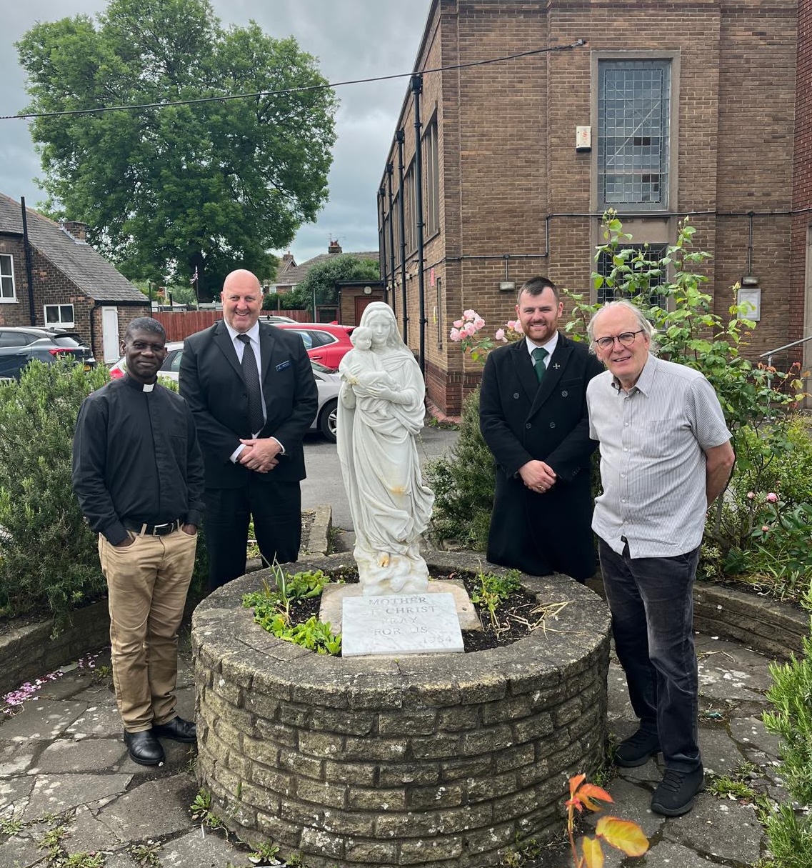 Father John Idio, left, and former parish priest Father Pat Day, right, with Matt Carr and Ben Dixon from Relph Funeral Directors